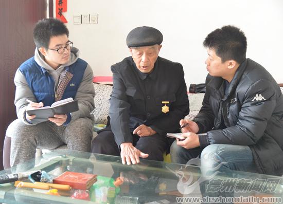 記者聽周化中老人（中）講抗日戰(zhàn)爭時的經歷。